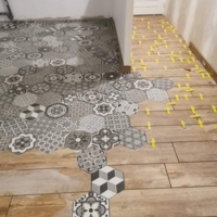 Réalisation d'une maison en placo et du carrelage avec une incrustation de carreaux de ciment dans du carrelage imitation parquet
