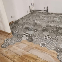 Réalisation d'une maison en placo et du carrelage avec une incrustation de carreaux de ciment dans du carrelage imitation parquet