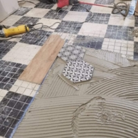 Réalisation d'une maison en placo et du carrelage avec une incrustation de carreaux de ciment dans du carrelage imitation parquet